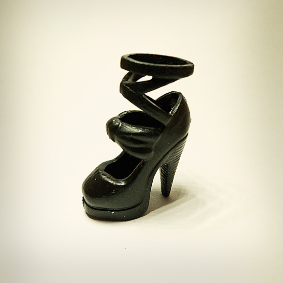 black Photographs of tiny plastic shoes for dolls