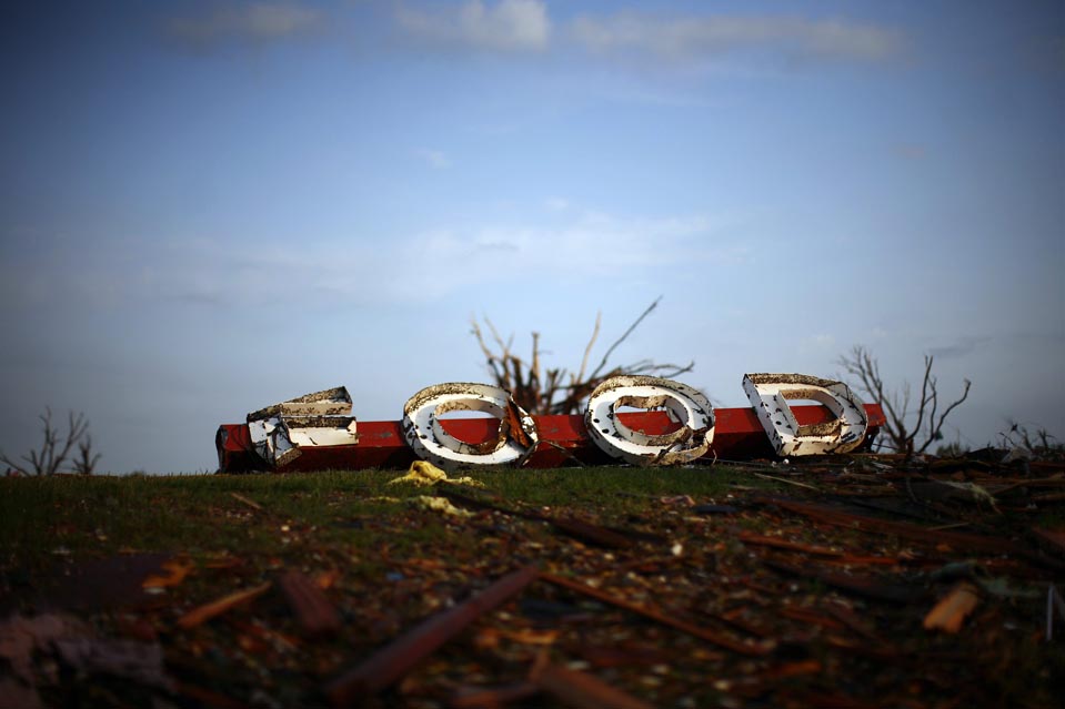 Sign Ripped Off A sign ripped from a market is seen after a devastating tornado hit ...