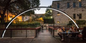 This Illuminated Arch Rises Up Out Of The Water And Surrounds A Foot Bridge In Texas