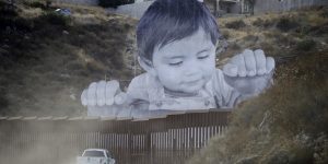 Giant Baby Looks Over Tecate, The US-Mexico Border Wall