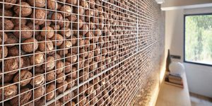 A Unique Accent Wall Was Made By Filling A Metal Cage With Walnuts