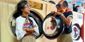 Taiwanese Elderly Couple In Their 80 Pose With Clothes Left Behind At Their Laundry Shop